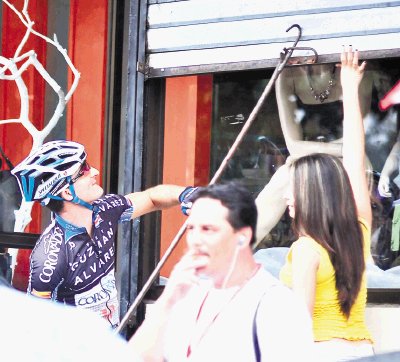   Paulo Vargas, del equipo Coronado-Bufete Guzm&#x00E1;n y &#x00C1;lvarez, dej&#x00F3; un momento su bicicleta de lado, para ayudar gentilmente a una dama, a poco de la salida en Gu&#x00E1;piles.