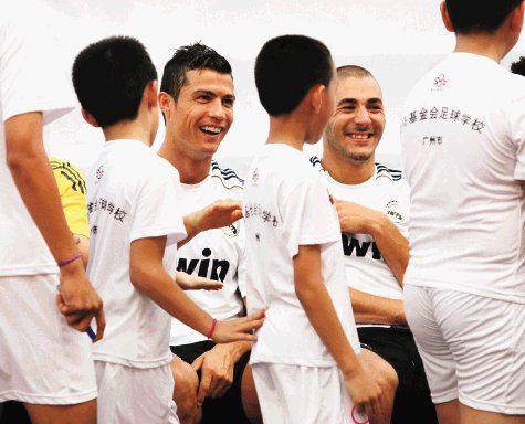  Mourinho tuvo que escapar. Cristiano Ronaldo y Karim Benzema saludan a unos niños chinos.EFE.