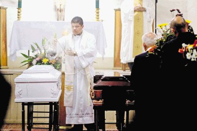 Los padres de los muchachos fallecidos son reconfortados a la salida de la iglesia . Marcela Bertozzi.