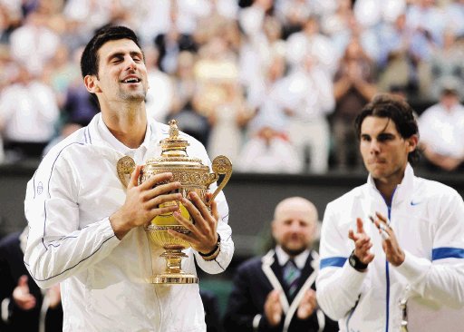 Djokovic demostró por qué es el número 1. El nuevo número uno del mundo acaricia la Copa, mientras Rafael Nadal, atrás, lo aplaude.AP