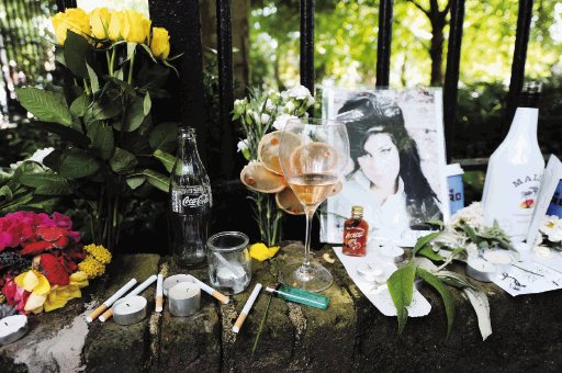 Amy Winehouse estaba mal antes de morir. Fans de la cantante colocaron cigarrillos y licor en un altar frente a su apartamento.AFP.