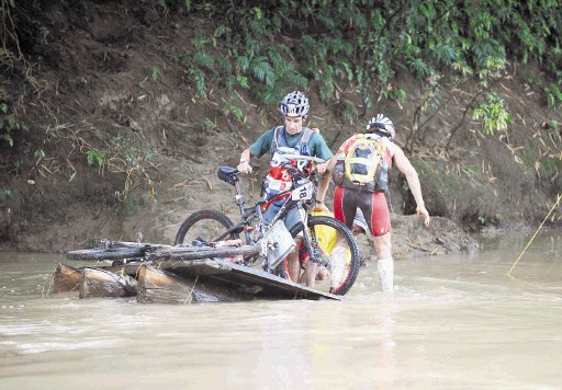  El gran desafío de los pies mojados. Dos integrantes del equipo Nissan Ecuador, por poco se hunden en una balsa al intentar cruzar el río Jiménez. Carlos Borbón.