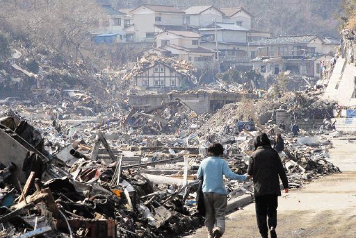 Una pareja camina a lo largo de los escombros en una zona residencial de Onagawa, al norte de Jap&#x00F3;n. AP.