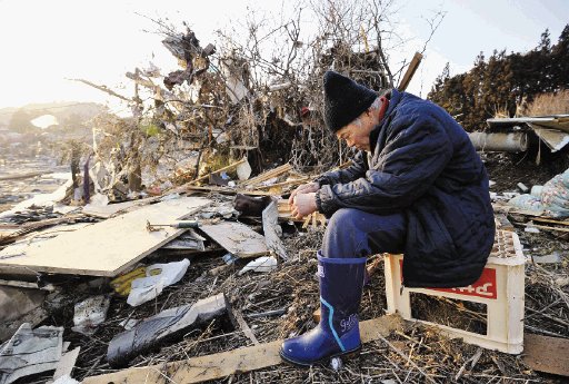 Un hombre se sienta abatido cerca de los escombros de su casa en la ciudad de Minamisanriku. AP.