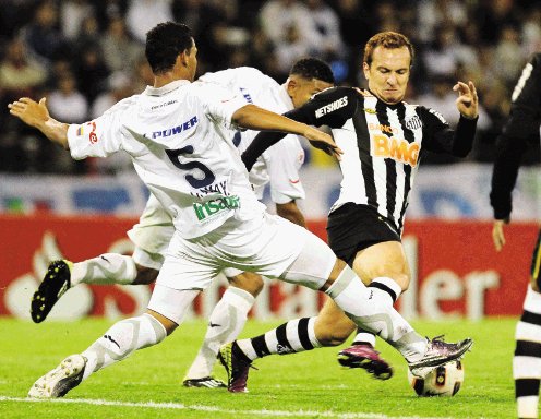  Grandes triunfan. José Eduardo Bischofe (d) del Santos de Brasil disputa el balón ante Diego Amaya (i) durante el partido de cuartos de final de la Copa Libertadores. EFE.