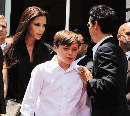 Mundo en imágenes. Victoria Beckham y su hijo Brooklyn se toparon a Marc Anthony. EFE.