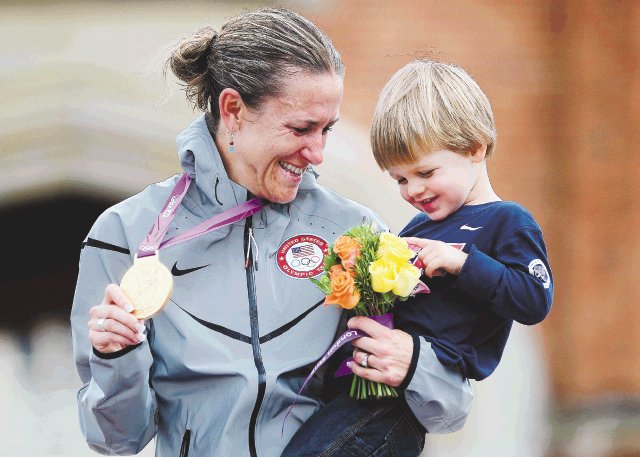  Logró ‘sacarse el clavo’. Con Lucas (de dos años) en brazos y mostrando el oro así se despidió Kristin Armstrong. AFP.