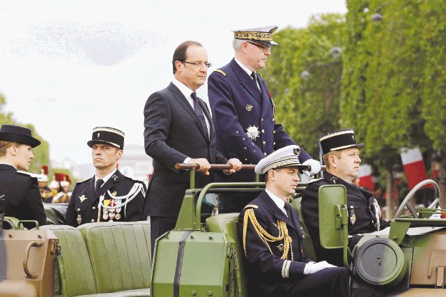  Festejo empañado. Hollande viajó en un vehículo militar. AFP.