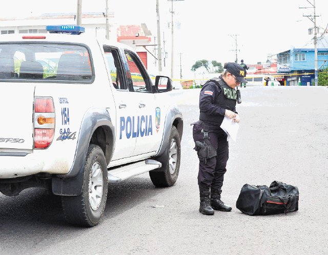  Narcos lanzan droga y escapan hacia León XIII. Una mujer policía no identificada custodiaba la tarde de ayer el maletín con droga que lanzaron en su huida dos traficantes que lograron burlar a un retén policial en La Uruca. Rebeca Arias.