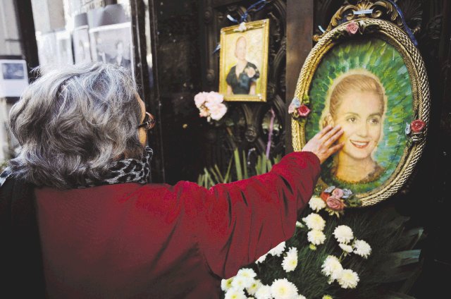  Tras 60 años lloran a “Evita”. Una mujer toca una pintura d e “Evita” en su tumba. AP.