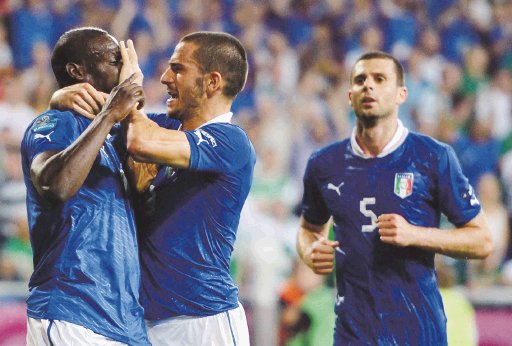  “No le tenemos miedo a nadie”. Leonardo Bonucci le tapa la boca a Mario Balotelli, quien quería sacar toda su rabia. AFP.