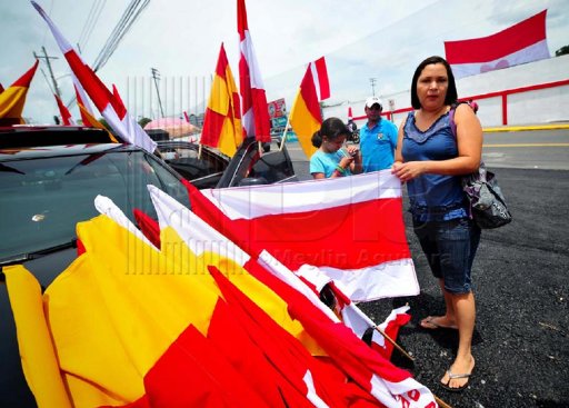 Heredia por media calle en Guápiles. Las banderas heredianos se venden como pan caliente en las afueras y alrededores del estadio. Meylin Aguilera.