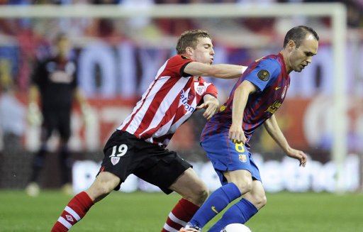 Barcelona golea al Athletic y gana la Copa del Rey. Iker Muniain del Athletic disputa el balón con Andrés Iniesta del Barcelona durante el juego de hoy. AFP.