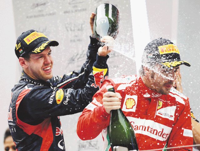  Vettel acelera al título. Vettel “bañó” en champán a Alonso para celebrar.AP.