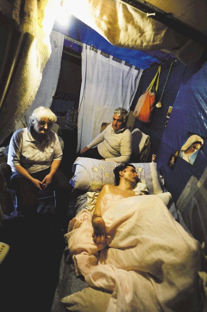 Muere joven en coma 23 años. Muchacho con sus padres en una carpa.AFP.